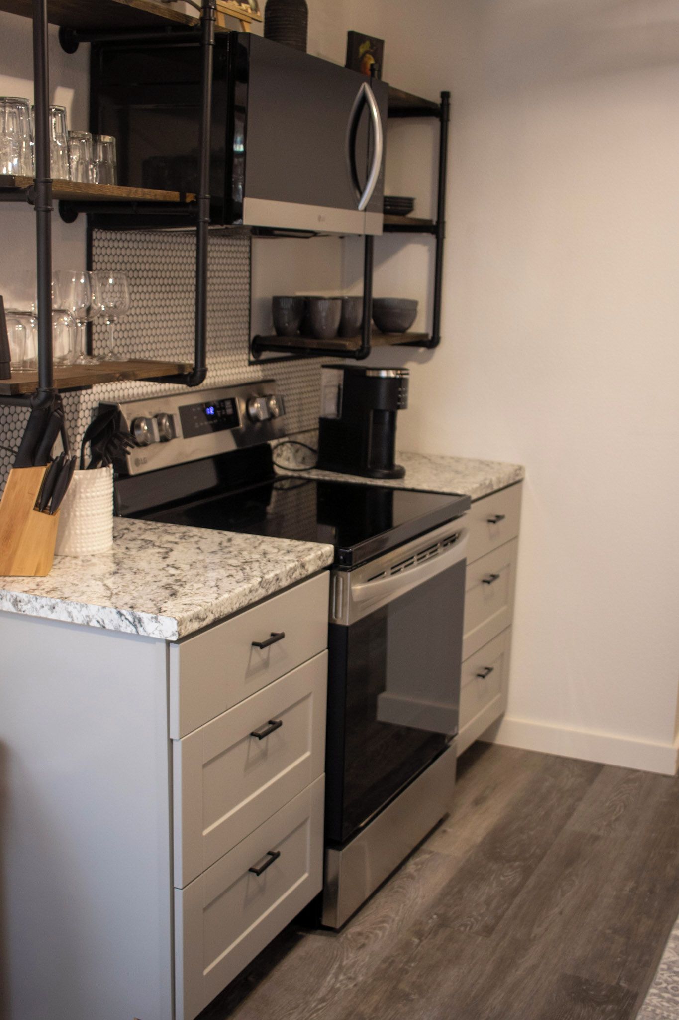 A modern kitchen with stainless steel appliances, a granite countertop, and a built-in oven.