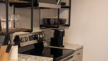 A modern kitchen with stainless steel appliances, a granite countertop, and a built-in oven.