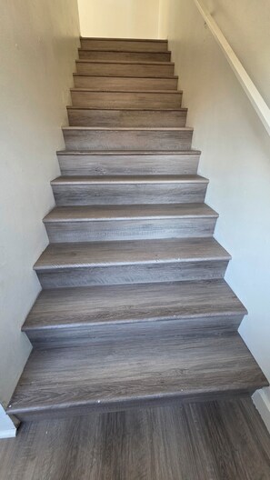 A wooden staircase with a handrail on the right side.