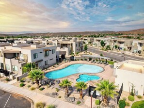 A residential area with modern houses, a swimming pool, and a clear sky.