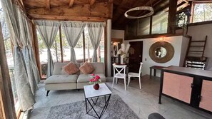 Ein gemütlicher Wohnbereich mit Sofa, Sesseln, einem Couchtisch und einem Esstisch.