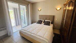 Un dormitorio con cama, armario y puerta corrediza de vidrio que da a un espacio exterior.