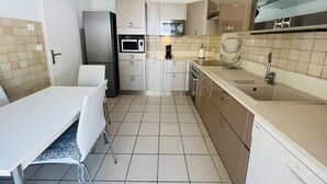 Una cocina moderna con comedor, electrodomésticos de acero inoxidable y lavavajillas.