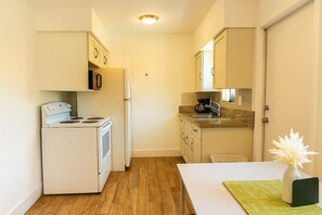 A compact kitchen with a stove, refrigerator, microwave, and sink. - U2 Cozy 1-Bedroom Miami · A/C & Parking · Steps from Vizcaya Metro and Brickell (Miami)