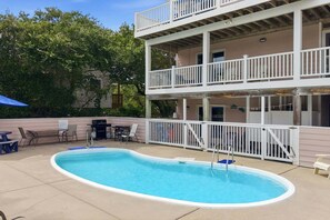 A two-story building with a swimming pool, outdoor seating, and a covered patio area. - 1819 - Always Dreaming Spacious 5BR Corolla retreat with pool, hot tub, and beach access. (Corolla)