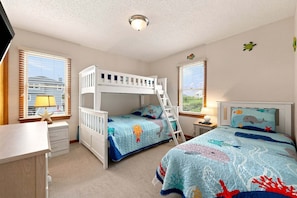 A bedroom with bunk beds, a desk, and a window with blinds. - 1819 - Always Dreaming Spacious 5BR Corolla retreat with pool, hot tub, and beach access. (Corolla)