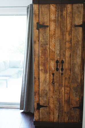 Ein Holzschrank mit Metallgriffen und ein Fenster mit Vorhängen.