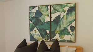 Una cama con ropa de cama blanca, almohadas oscuras y un cabecero de madera.