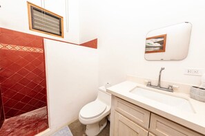A bathroom with a toilet, sink, and shower.