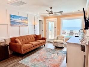 A living room with a sofa, armchair, and a view of the ocean. - Oceanfront 8BR Oak Island home with private heated pool. (Oak Island)