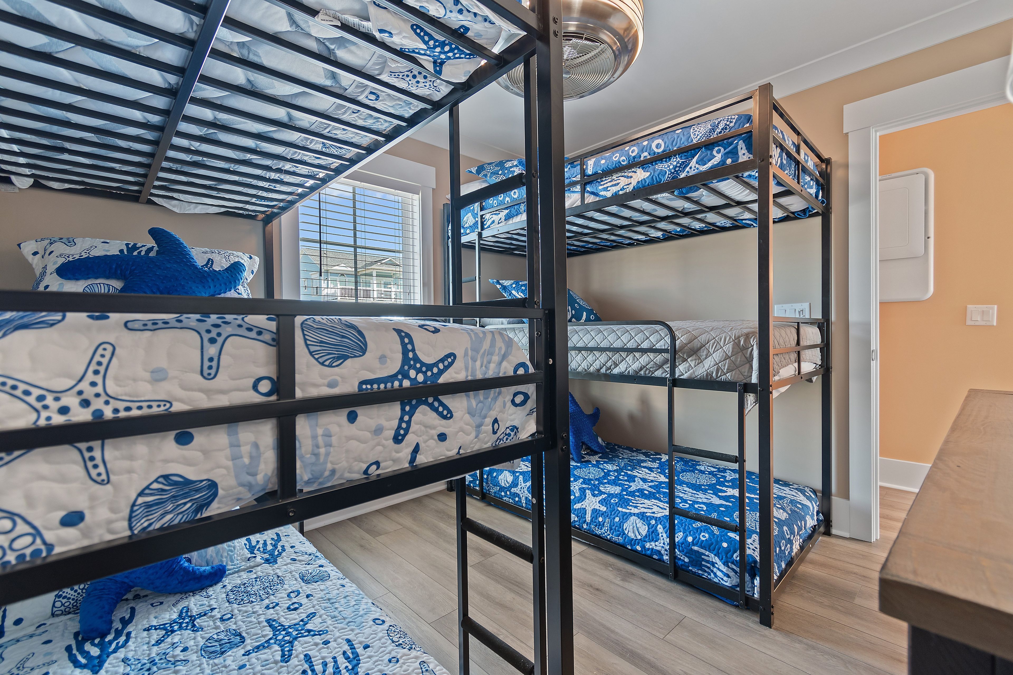 A bunk bed room with a window and a ceiling fan.