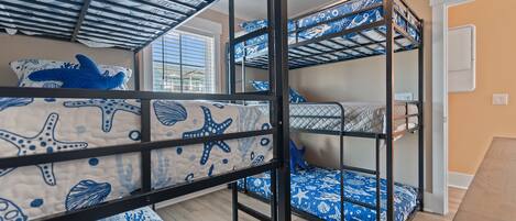 A bunk bed room with a window and a ceiling fan.