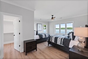 A bedroom with two beds, a ceiling fan, a nightstand, and a window with a view of the water. - Waterview Oasis | Pool & hot tub| Game Room | Outdoor Kitchen (Terrell)