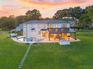 A two-story house with a swimming pool, outdoor seating, and a covered patio. - Waterview Oasis | Pool & hot tub| Game Room | Outdoor Kitchen (Terrell)