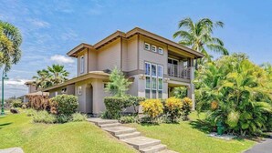 A two-story house with a balcony, surrounded by well-maintained lawns and palm trees. - *NEW* Fall Special Pool and Tennis Days Near Anaeho'omalu Bay (Waikoloa)