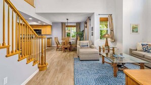 A spacious living area with a staircase, a dining area, and a kitchen. - *NEW* Fall Special Pool and Tennis Days Near Anaeho'omalu Bay (Waikoloa)