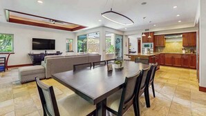 A modern kitchen with a dining area, large windows, and a flat-screen TV. - NEW Mauna Lani Space, Pool Time, and Kohala Coast Sun (Waimea)