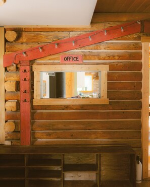 A wooden cabin interior with a sign labeled 'OFFICE' above a window. - Rustic Lakefront Lodge on Little Atlin Lake - Pet friendly! (Tagish)