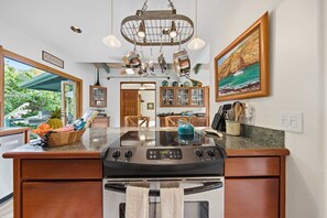 A kitchen with a central island, stainless steel appliances, and a view of the outdoors.