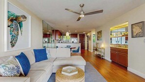A modern living room with a sofa, a coffee table, and a ceiling fan. - *NEW* Kona Sunsets from a Ground Floor Ocean View Lanai (Kailua-Kona)