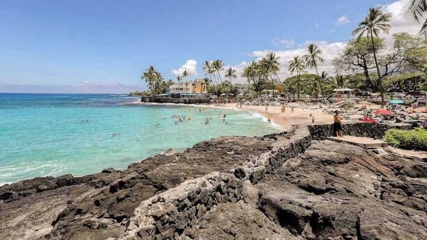 A coastal beach with rocky terrain, clear turquoise waters, and palm trees. - *NEW* Kona Sunsets from a Ground Floor Ocean View Lanai (Kailua-Kona)