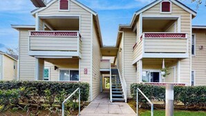 A row of two-story apartment buildings with balconies, a central staircase, and a gated entrance. - *NEW* Fall $pecial Heated Pool, Hot Tub and Golf in Waikoloa Village (Waikoloa Village)