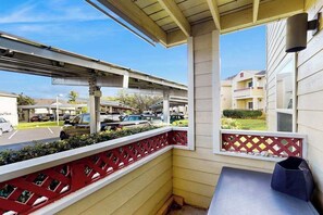A balcony with a red lattice railing, a table, and a chair. - *NEW* Fall $pecial Heated Pool, Hot Tub and Golf in Waikoloa Village (Waikoloa Village)
