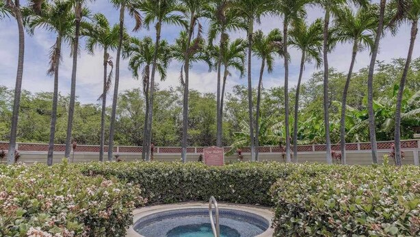 A swimming pool surrounded by lush greenery and tall palm trees. - *NEW* Fall $pecial Heated Pool, Hot Tub and Golf in Waikoloa Village (Waikoloa Village)