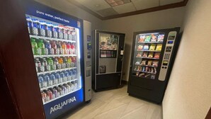 A vending area with a water dispenser labeled AQUAFINA, a snack vending machine, and a beverage dispenser.