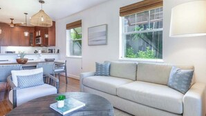 Uma sala de estar moderna com sofá, mesa de centro e área de jantar.