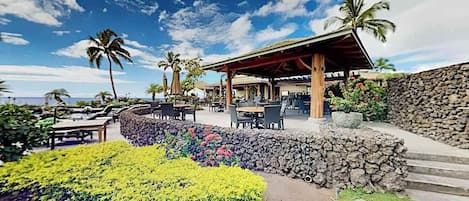 Ein Resort mit Außenbereich, Palmen und einer Steinmauer.