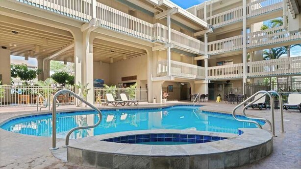 Ein mehrstöckiges Hotel mit Pool, Außenbereich und überdachter Terrasse.