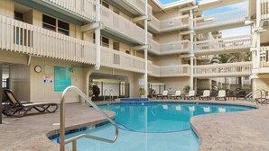 Ein mehrstöckiges Hotel mit Schwimmbad, Außenbereich und Balkon.