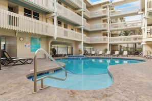 Un hôtel à plusieurs étages doté d’une piscine, d’un espace extérieur aménagé et d’un balcon.
