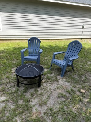 Two Adirondack chairs and a round table in a grassy outdoor area. - Quaint two bedroom two bath handicapped home is located in Brookeland , TX. (Brookeland)