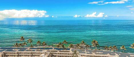 A hotel with multiple buildings, a pool area, and a view of the ocean.