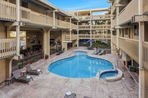 Un hôtel à plusieurs étages doté d’une piscine centrale, d’un espace extérieur aménagé et d’un patio couvert.