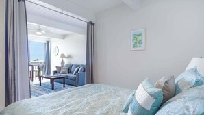 Een slaapkamer met een bed, een bank, een tafel en uitzicht op het buiten.