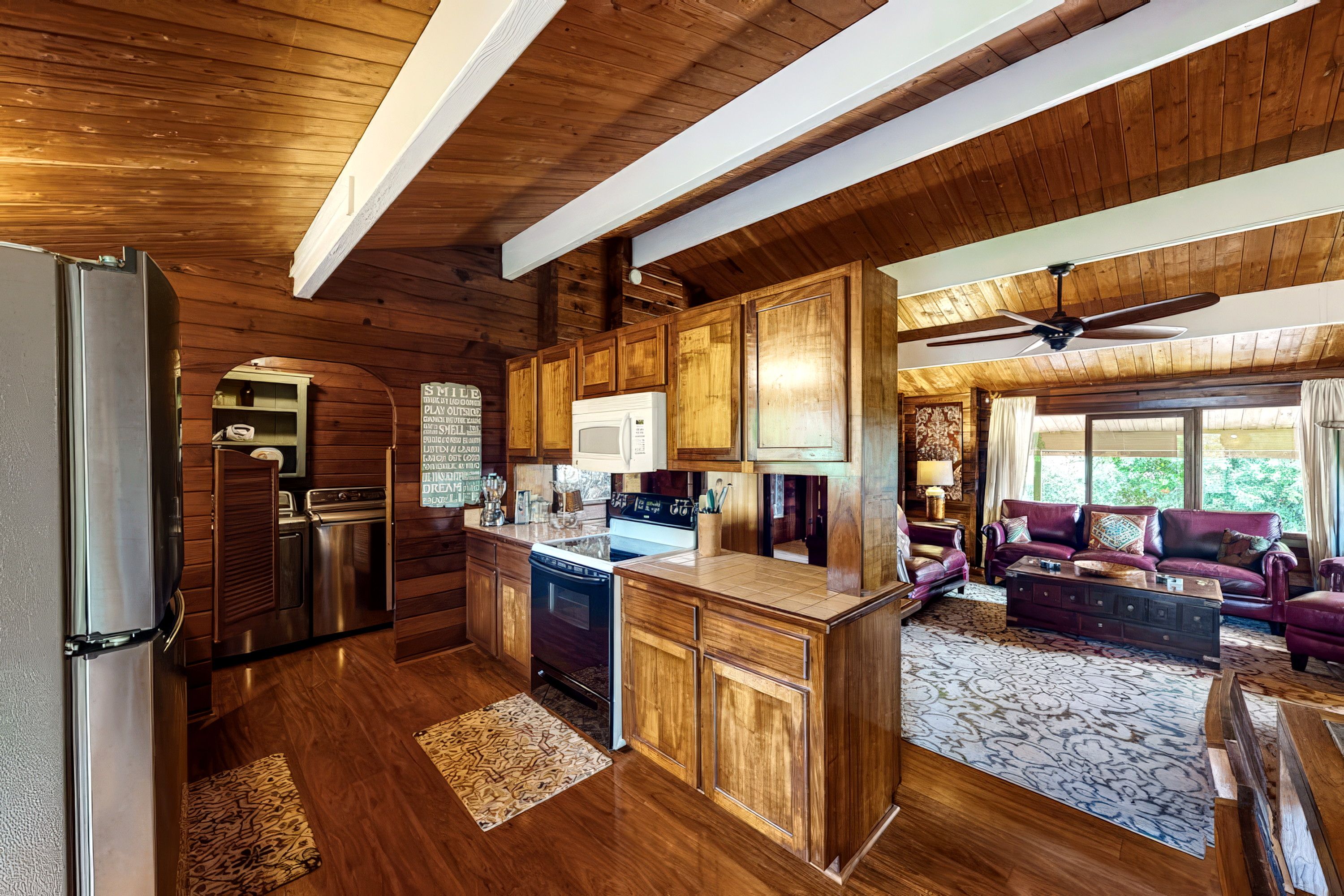 A spacious kitchen with wooden cabinets, a refrigerator, and a dishwasher.