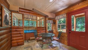 A log cabin interior with a dining area, a red door, and large windows. - Z - Bear Crossing (Sevierville)