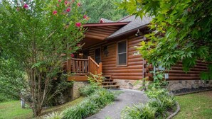A log cabin with a porch, stone foundation, and a pathway leading to the entrance. - Z - Bear Crossing (Sevierville)