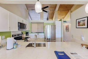 A modern kitchen with white cabinets, stainless steel appliances, and a central island. - *New* Ocean and Fairway Views from a Waikoloa Villa (Waikoloa Village)