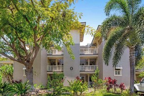 A multi-story building with balconies, surrounded by lush greenery and trees. - NEW Fall Sale Golf-View Family Escape Near A-Bay Beach (Waikoloa)
