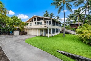 Une maison à deux étages avec un porche abrité, un garage et une pelouse bien entretenue.