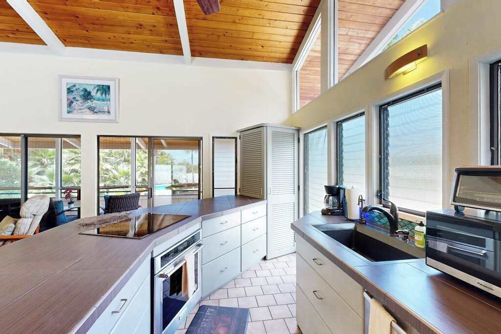 A kitchen with a large island, built-in oven, and a view of the outdoors.