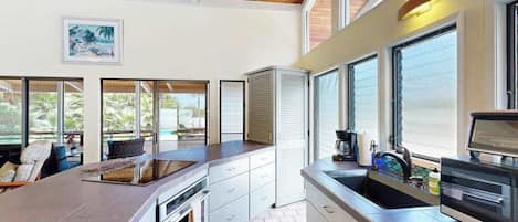 A kitchen with a large island, built-in oven, and a view of the outdoors.