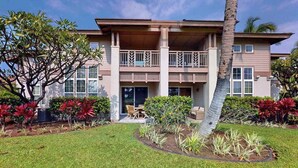 A two-story house with a balcony, surrounded by a well-maintained garden and a lawn. - *NEW* Fall Sale Two Lanais on the Fairway at Waikoloa Colony Villas (Waikoloa Village)