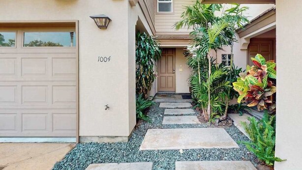 A residential entryway with a garage, a door marked '1004', and a pathway leading to the house. - *NEW* Fall Sale Two Lanais on the Fairway at Waikoloa Colony Villas (Waikoloa Village)