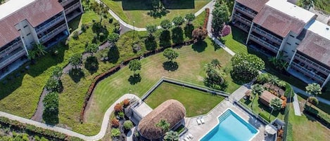 Eine Vogelperspektive auf ein Hotel mit einem zentralen Schwimmbad, mehreren Gebäuden und angelegten Gärten.