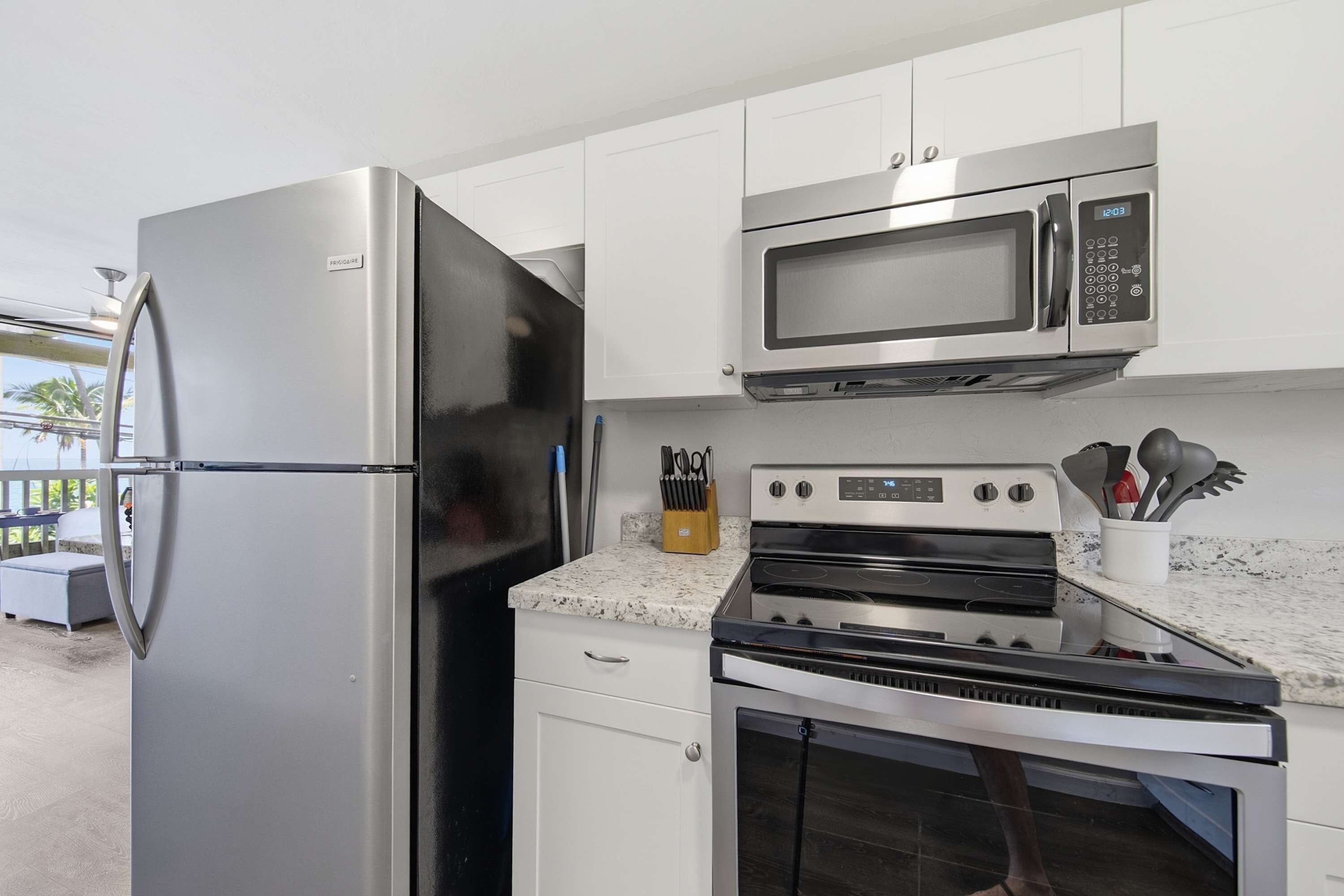 A kitchen with stainless steel appliances including a refrigerator, microwave, oven, and stove.